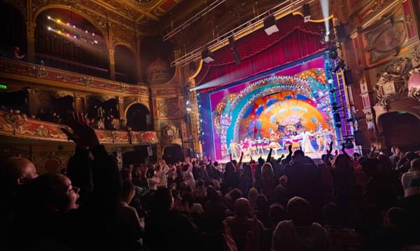 A photo taken from the back of the Stalls in Hackney Empire, showing an audience on their feet applauding Mother Goose in 2022.