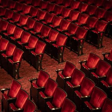 A photo taken from the Dress Circle looking down on rows of chairs in the Stalls.