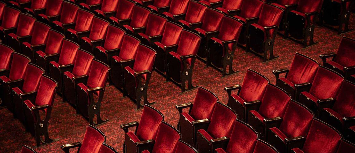 A photo taken from the Dress Circle looking down on rows of chairs in the Stalls.
