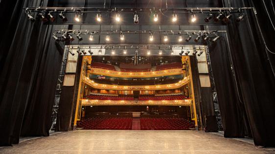 A photo taken from the very back of the stage, showing the whole stage space and the auditorium behind it.