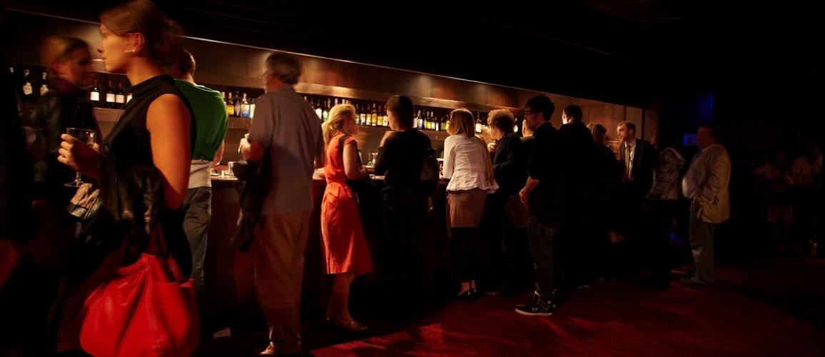 People gathered near the bar in the back of the stalls at Hackney Empire