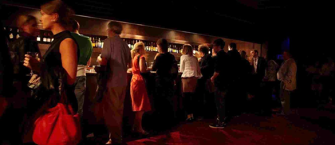 People gathered near the bar in the back of the stalls at Hackney Empire