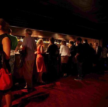 People gathered near the bar in the back of the stalls at Hackney Empire