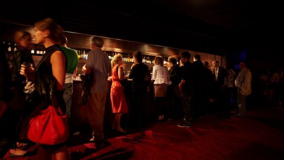 People gathered near the bar in the back of the stalls at Hackney Empire