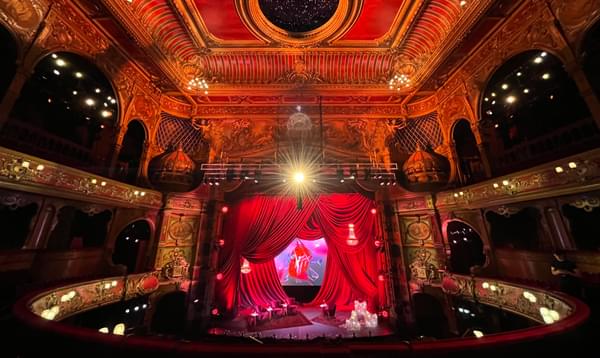 A photo of Hackney Empire's auditorium with the stage setup with the iconic Rolling Stones symbol and red curtains.
