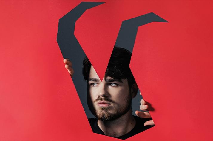 A red graphic background with horns cut out of it. Behind this graphic is a man's face with hands held up as if trying to get out of the horns.