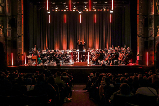 A photo of BBC Symphony Orchestra performing, taken from the back of the audience.