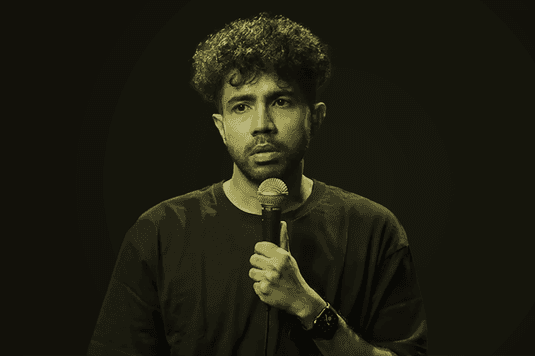 Image of Abhishek Upmanyu holding a microphone up to his mouth.