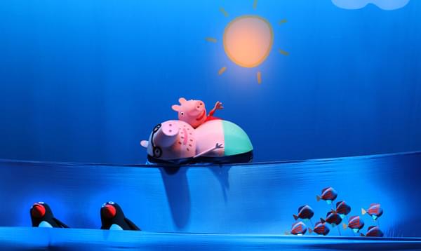 Peppa Pig and Daddy pig are taking a swim in the sea on the beach.