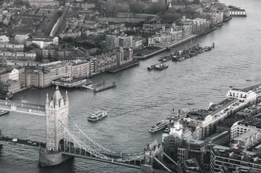 A black and white photo of London showing Tower Bridge and the Thames.