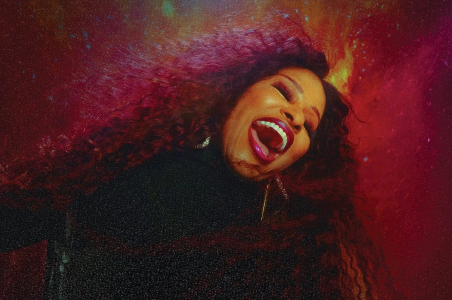 A woman singing passionately against a red background