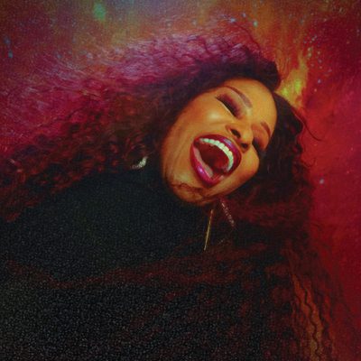 A woman singing passionately against a red background