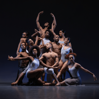 A group of dancers strikes a pose for a photo, displaying their colorful attire and enthusiastic expressions.