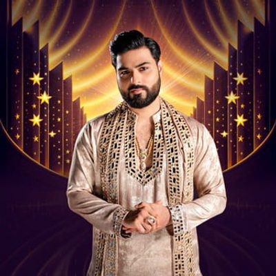 A man in embroidered traditional attire stands confidently with a gentle smile. The background features a starry, radiant design, creating a majestic tone.