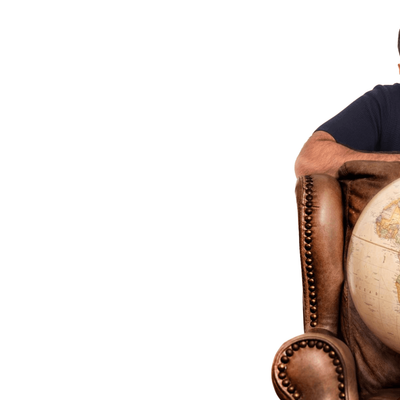 Tez Ilyas is sitting down with a globe on his chair, representing a connection to the world and global knowledge.