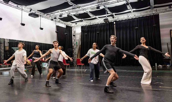 The Cinderella Ensemble dancing together with arms outstretched