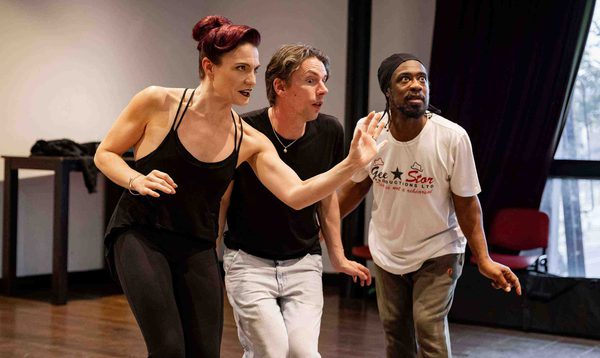 Alexandra Waite-Roberts as Oblivia is gesturing with an evil expression whilst George Heyworth and Kat B as the Ugly Sisters listen in.