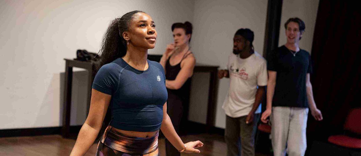 Siobhan James as Cinderella is looking up at the air with a hopeful expression