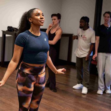 Siobhan James as Cinderella is looking up at the air with a hopeful expression