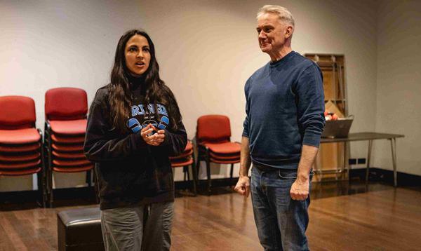 Aryana Ramkhalawon as Alice Fitzwarren is singing out to the front whilst Tony Timberlake as Alderman Fitzwarren faces her smiling.
