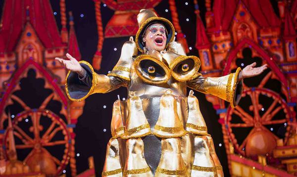Clive Rowe as Sarah the Cook in the Finale of the show. Clive is wearing a dress completely covered in gold bells.