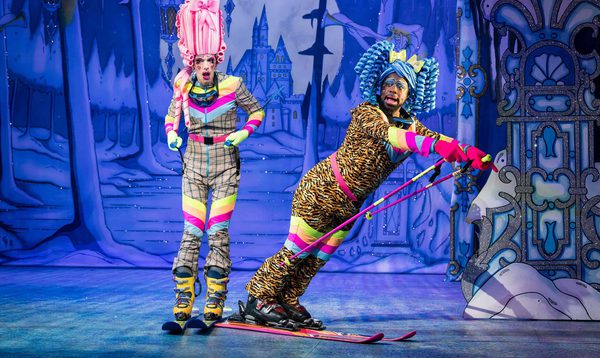 George Heyworth as Nausea and Kat B as Flatula are wearing ski outfits and posing on skis.