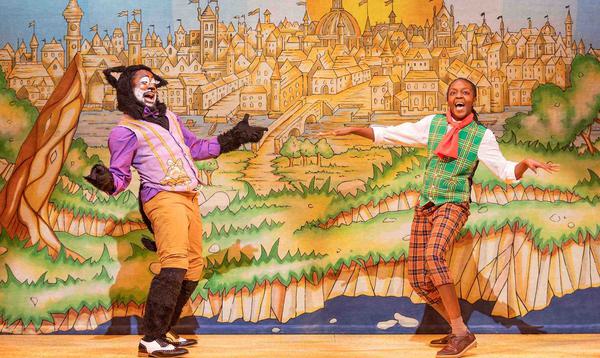 Kat B as Tommy the Cat and Kandaka Moore as Dick Whittington are dancing facing each other, smiling with their bodies turned towards the audience.