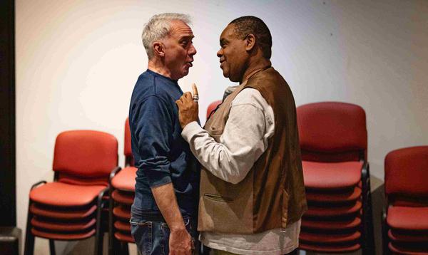 Tony Timberlake as Alderman Fitzwarren and Clive Rowe as Sarah the Cook are stood close together singing towards each other in a romantic way.