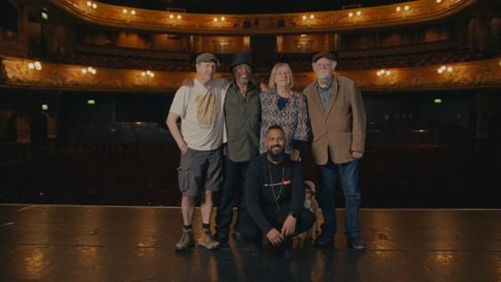 Brian Wren, Othman Read, Claire Muldoon, Roland Muldoon and Yamin Choudury pose together in the centre of the Hackney Empire stage with the auditorium behind them.