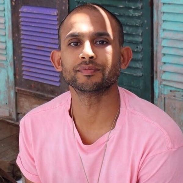 Soheb Panja wearing a pink t-shirt and staring straight at camera with his head half in sunlight