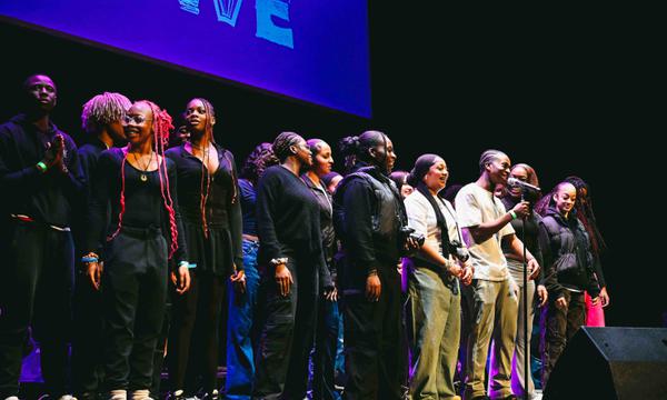 A photo of Hackney Empire Creative Futures cohort on stage together performing a piece of spoken word.