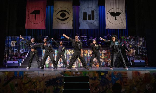 The dancers in ADP 2024 wearing all black with one arm outstretched to the right of them.