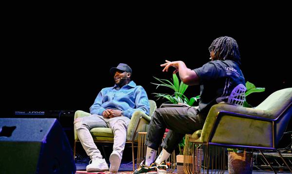 A photo of Yomi Sode and Rapman sat on stage together having a conversation.