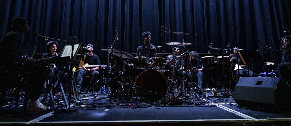 The ADP band are on Hackney Empire's main stage sitting behind their instruments waiting to play
