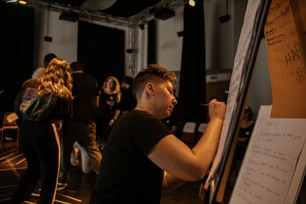 Participants in The Studio 2025 writing ideas on a flip chart